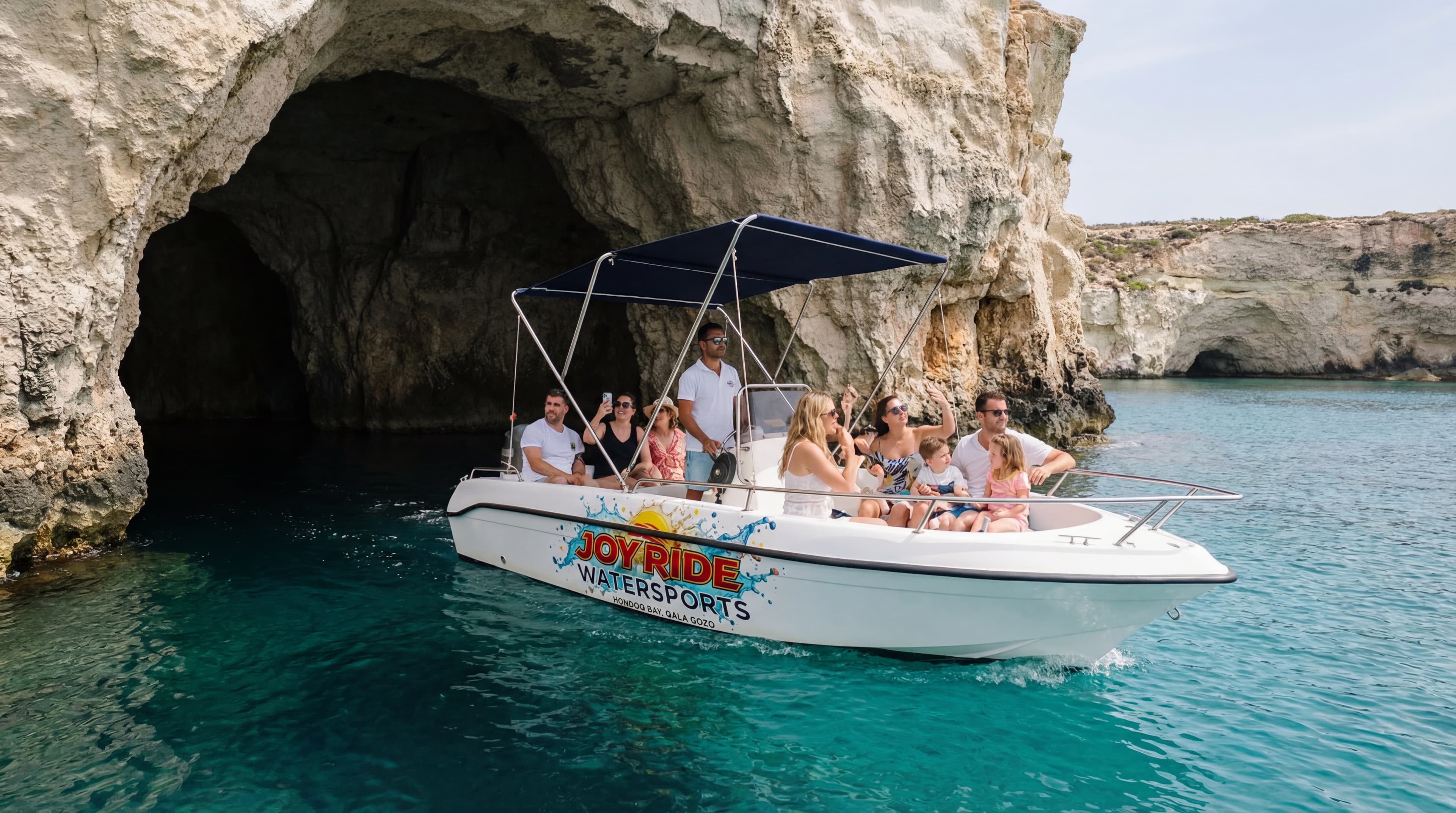 Tour boat entering Comino sea cave with Blue Lagoon in background