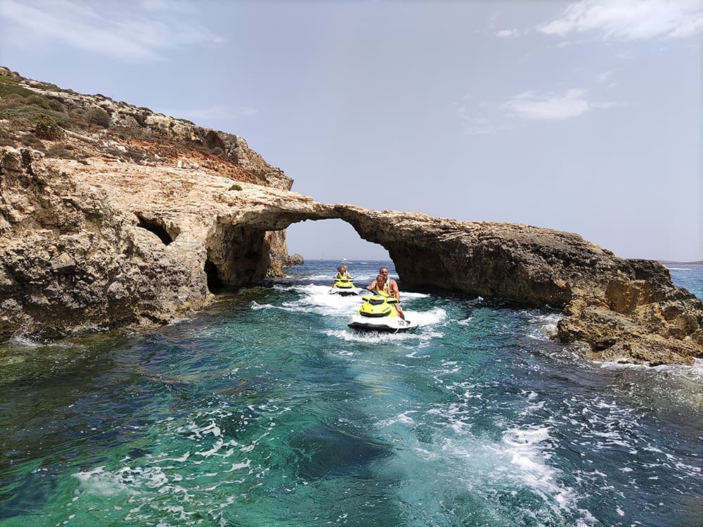 Jet ski safari group near a Comino cave